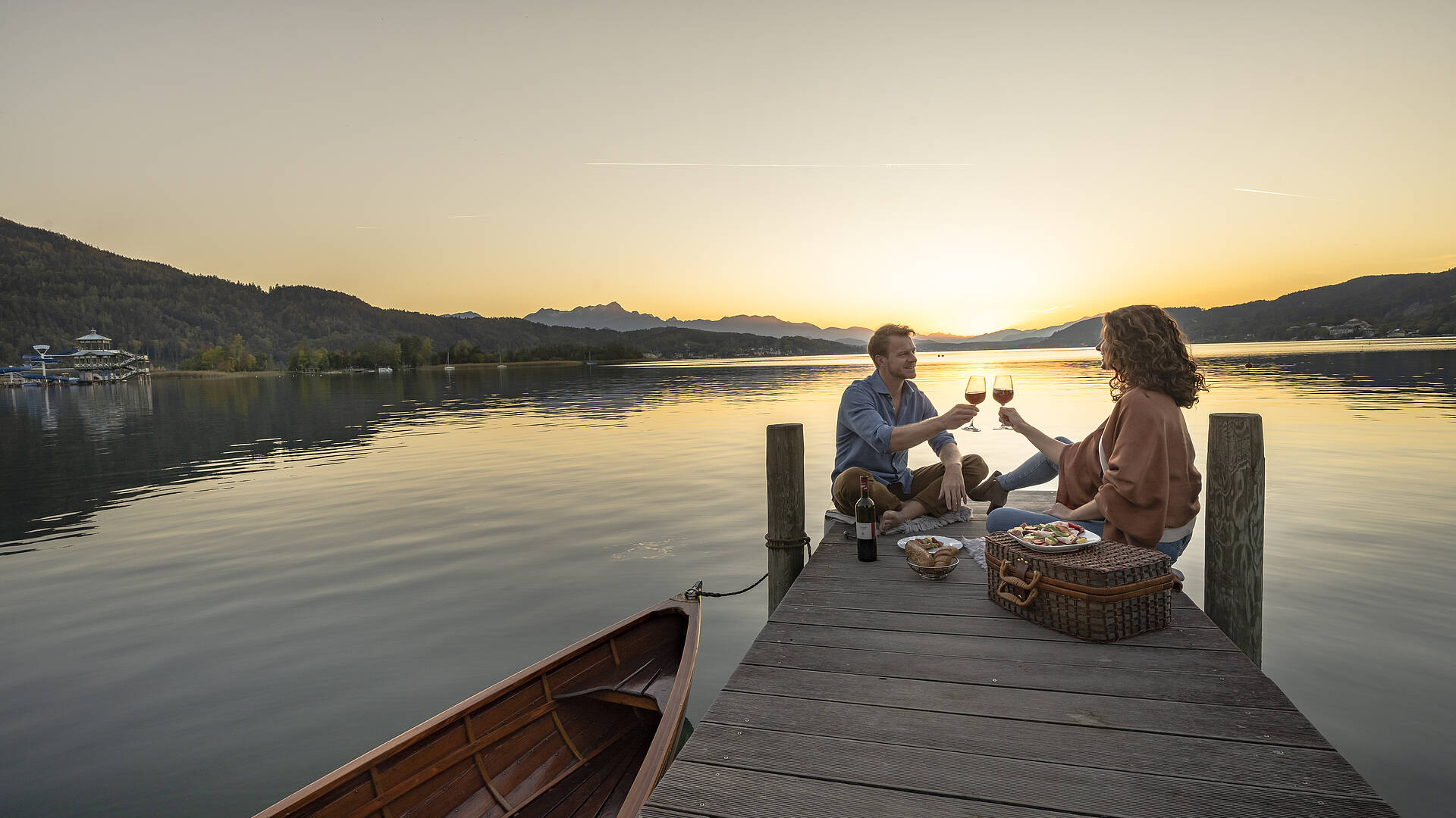 Paerchen beim Picknick am Steg am Woerthersee