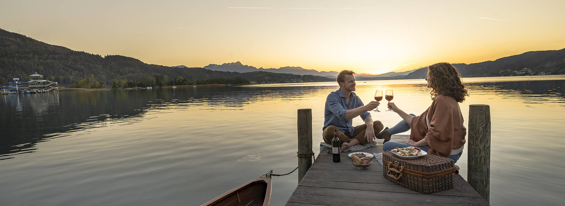 Paerchen beim Picknick am Steg am Woerthersee